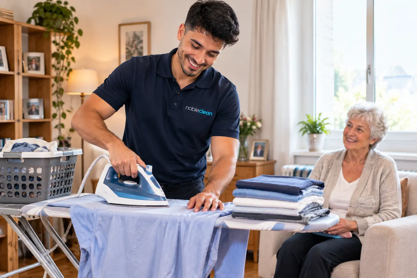 Alltagsbegleiter von nobleclean b&uuml;gelt W&auml;sche im Wohnzimmer einer Kundin.